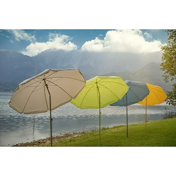 Sunfun Strandschirm - Blau, Durchmesser Bespannung: 180 cm - Vier bunte Strandschirme (beige, lindgrün, blau, gelb) stehen am grasbewachsenen Ufer eines ruhigen Sees vor Bergen unter bewölktem Himmel.