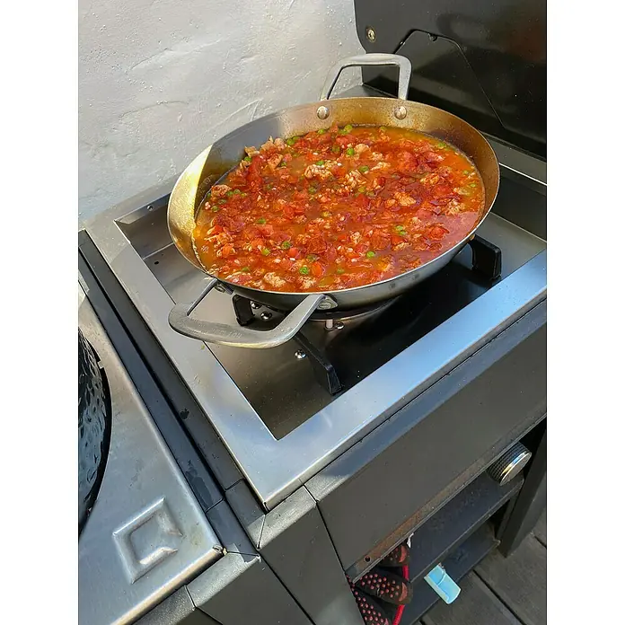 oneQ Outdoorküche - 4 -tlg., Stahl/Edelstahl/Bambus, Schwarz, Anzahl Brenner: 1 - Ein großer Topf mit einer köstlichen Mahlzeit steht auf einem Herd. Es sieht aus wie ein Eintopf oder eine Suppe mit Fleisch und Gemüse.