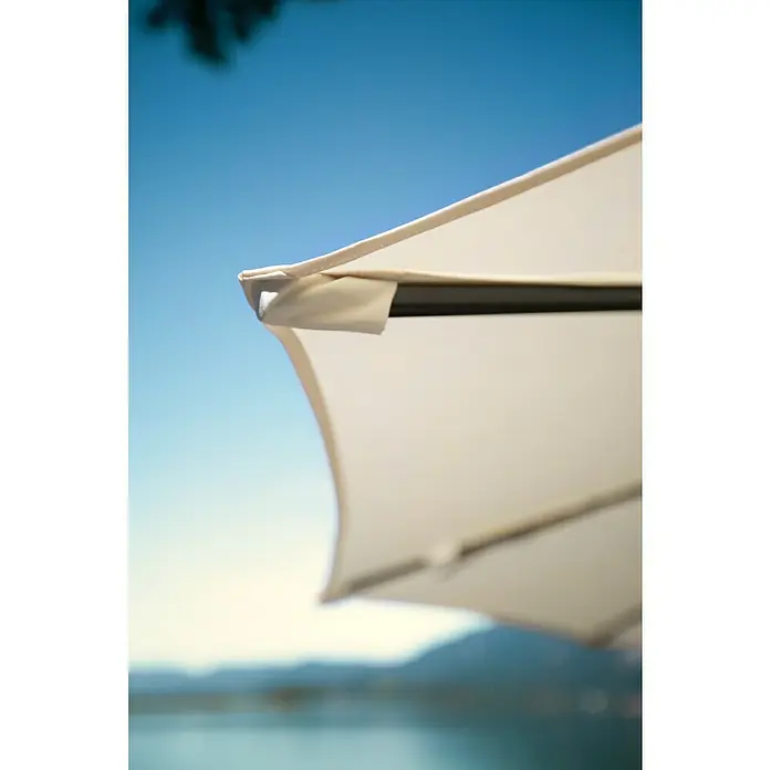Sunfun Schirmbezug Capri - Natur, Passend für: Sunfun Ampelschirmgestell Capri Ø 300 cm - Nahaufnahme eines weißen Sonnenschirms mit blauem Himmel im Hintergrund, ideal für sonnige Tage im Freien.