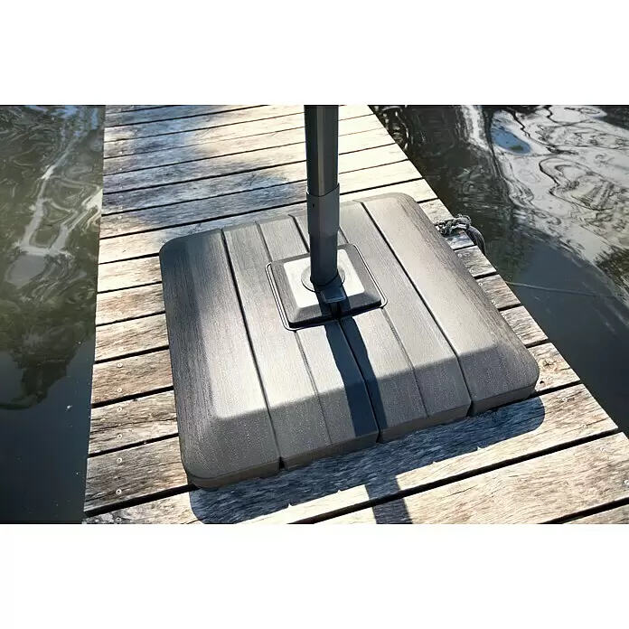 Sunfun Ampelschirm Capri - Rot, Bespannungsmaß (L x B): 300 x 350 cm - Dunkelgrauer, strukturierter Kunststoff-Schirmständer mit Stange auf einem Holzsteg am Wasser.
