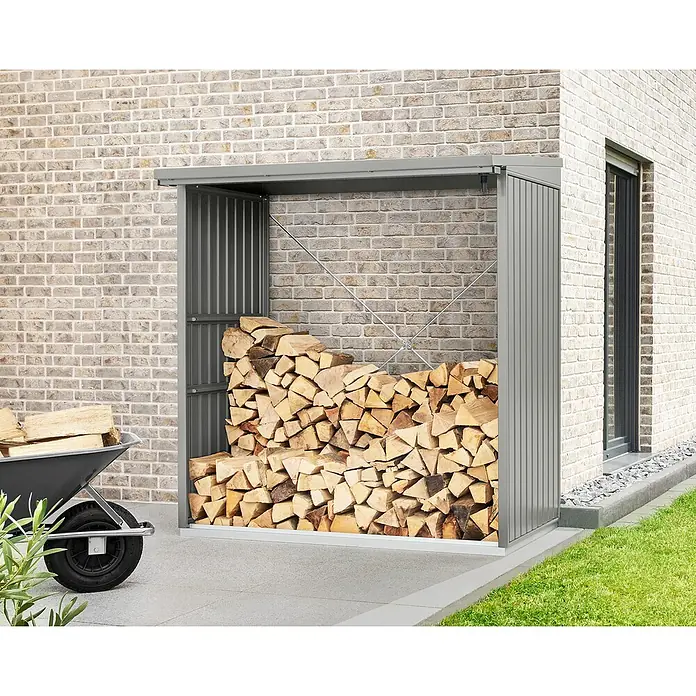 EcoStar Kaminholzregal Trend-V Typ 2 - Metall, Grau - Das Bild zeigt ein graues Holzregal aus Metall, gefüllt mit gespaltenem Brennholz, neben einer Schubkarre mit Holz.