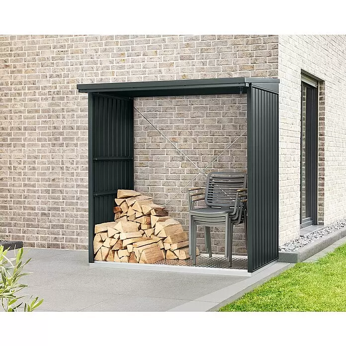 EcoStar Kaminholzregal Trend-V Typ 2 - Metall, Anthrazitgrau - Dunkelgraues Metall-Holzlager auf einer Terrasse vor einem Haus, gefüllt mit Holzscheiten und Stühlen.