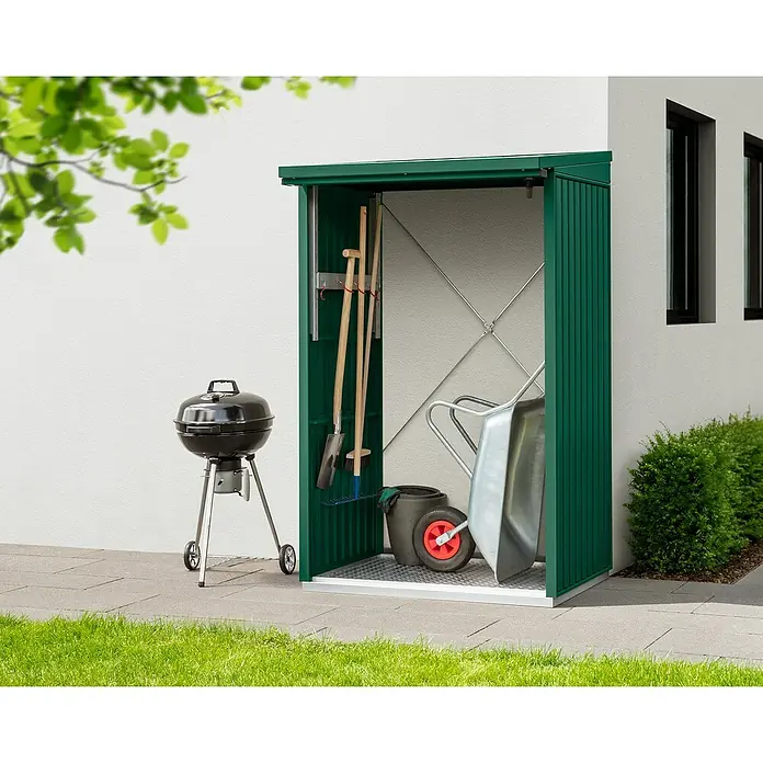 EcoStar Kaminholzregal Trend-V Typ 1 - Metall, Moosgrün - Gartengeräteschrank aus grünem Metall mit Grill, Schaufel, Harke und Schubkarre auf einer Steinterrasse mit Rasenfläche.