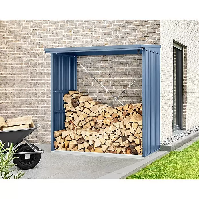 EcoStar Kaminholzregal Trend-V Typ 2 - Metall, Taubenblau - Blauer Metall-Holzunterstand, gefüllt mit gestapeltem Brennholz, neben einem Ziegelhaus mit Schubkarre. Hält das Holz trocken und organisiert.