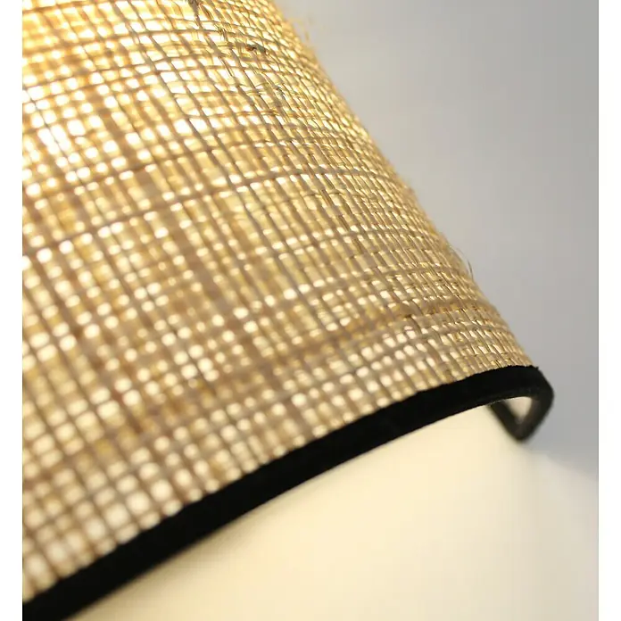 Idp Lampshades Fine negra Aplique de pared - L x An x Al: 10 x 20 x 20 cm, Natural/Negro - Primer plano de una pantalla de lámpara de cesto tejido con ribete negro, que emite una luz cálida y difusa creando un ambiente acogedor.