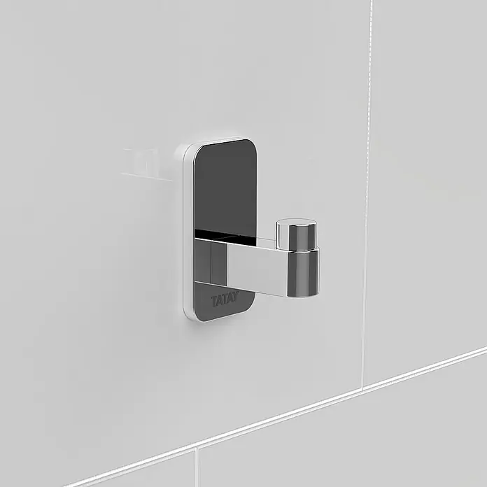 Tatay Slim Colgador - Cromo - Primer plano de un colgador de pared plateado Tatay montado en una pared blanca, que ofrece una solución de almacenamiento elegante.