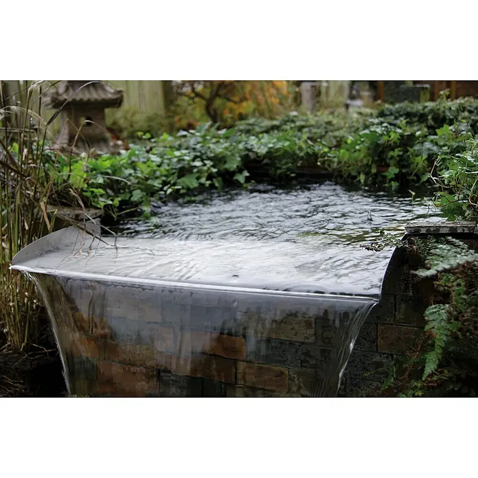 Ubbink Überlauf-Element Brisbane - L x B x H: 25 x 30 x 6 cm - Nahaufnahme eines Wasserfalls mit Ziegelsteinen und üppigem Grün, der Ruhe und die Schönheit eines Gartenteichs hervorhebt.