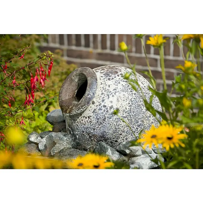 Ubbink AcquaArte Springbrunnen-Set Orange - Keramik, Natur - Dekorativer Gartenbrunnen mit einer rustikalen Amphore, umgeben von blühenden Blumen und grüner Vegetation, der eine friedliche Atmosphäre schafft.
