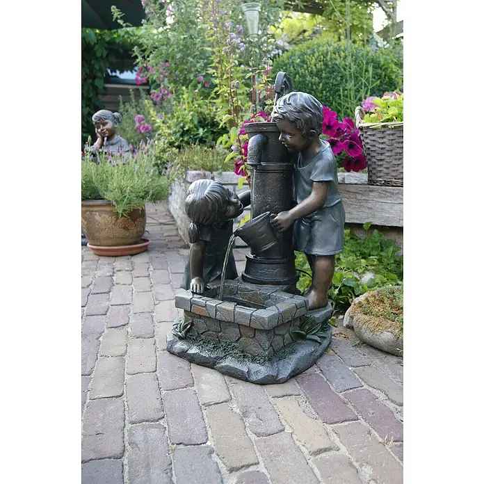 Ubbink AcquaArte Gartenbrunnen Atlanta - 39,5 x 44 x 69,5 cm, Kunststoff, Bronze - Detailaufnahme eines Brunnens mit zwei spielenden Kinderskulpturen im Garten, umgeben von üppiger Vegetation.