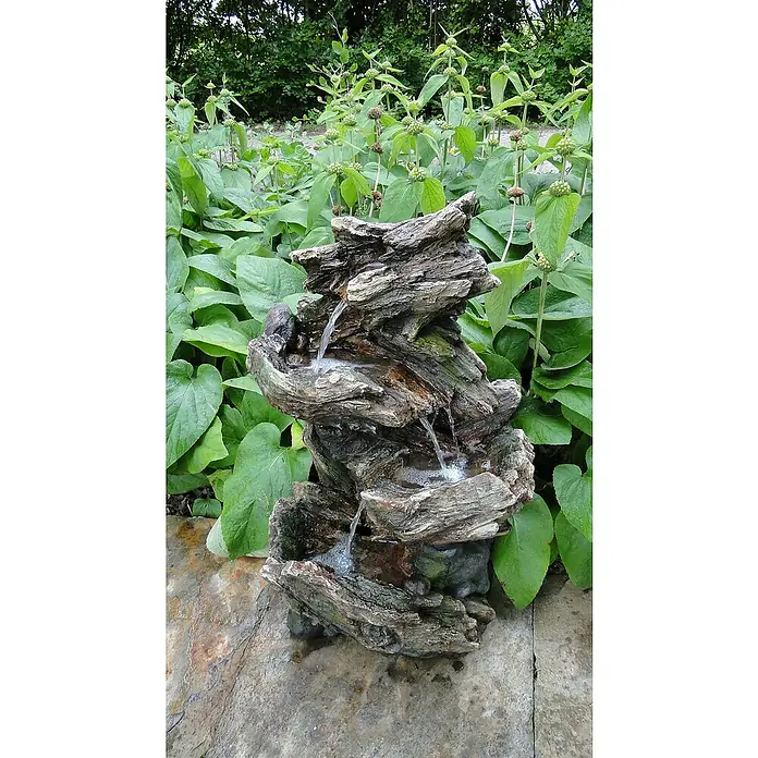 Ubbink AcquaArte Gartenbrunnen Vernier - 36 x 46 x 78 cm, Kunststoff, Braun - Dekorative Zimmerbrunnen-Szene, die einen rustikalen Holzbrunnen inmitten üppiger grüner Pflanzen zeigt, perfekt für eine friedliche Atmosphäre.