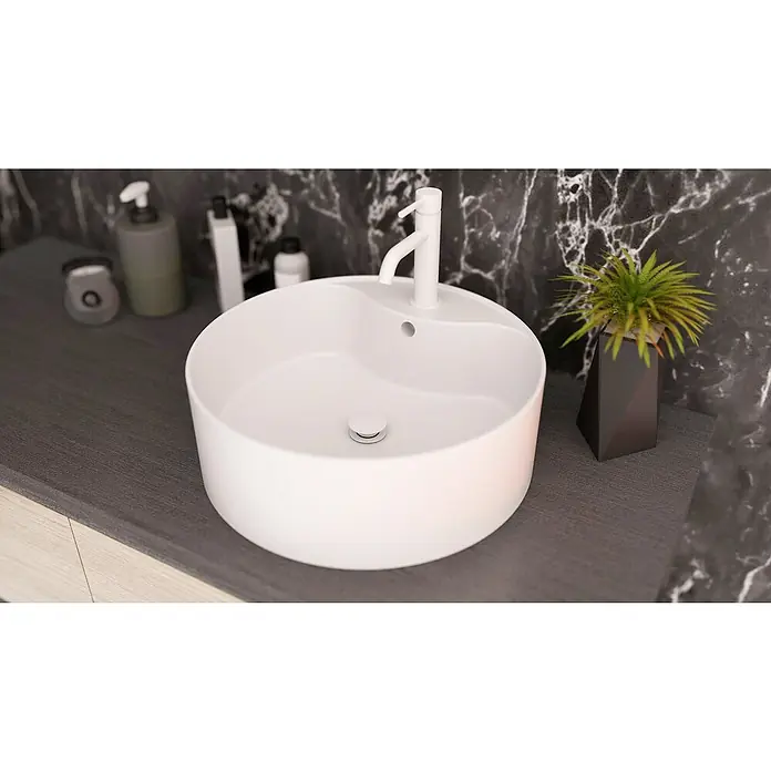 IO Válvula click clack - 1¼'', Blanco - Elegante conjunto de lavabo de baño. Lavabo sobre encimera redondo blanco con grifo y planta, sobre mármol oscuro, combina estética moderna.