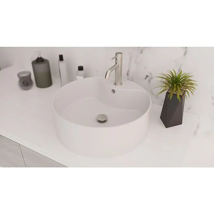 IO Válvula click clack - 1¼'', Cromo - Un lavabo blanco redondo y elegante con un grifo moderno y elementos decorativos para un baño de diseño.