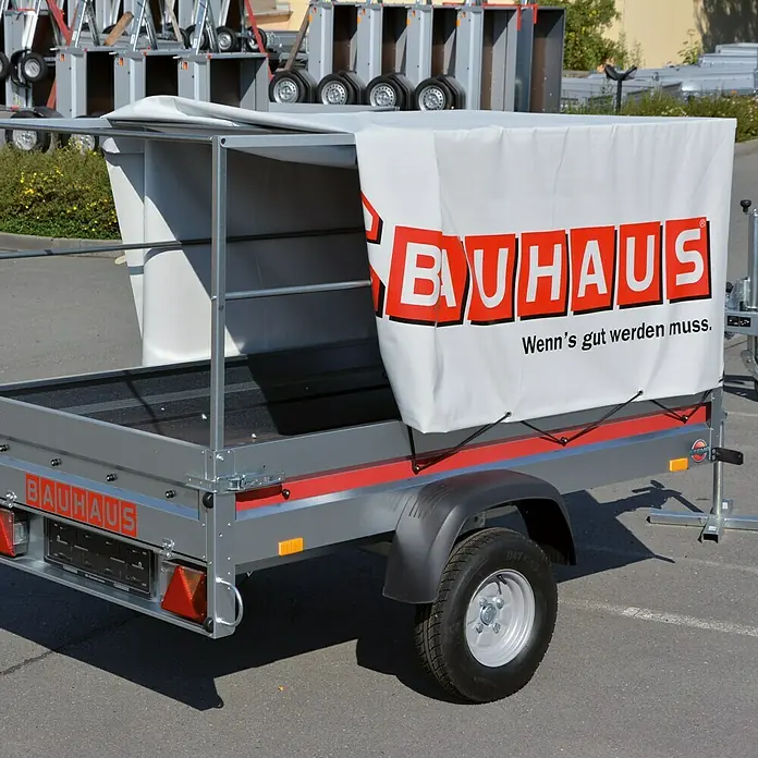Stema Anhänger BH 7.5-20-12.1 - Nutzlast: 605 kg, Einachser, Ungebremst - Hier ist ein PKW-Anhänger von Bauhaus mit Plane. Der Anhänger ist silbern und hat eine rote Zierleiste.