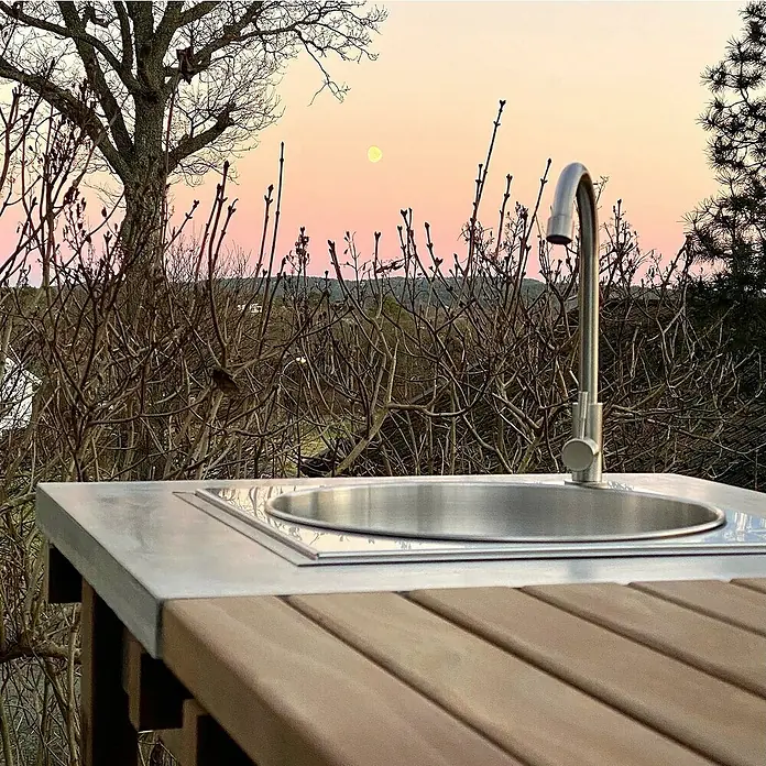 oneQ Einbauspüle - 40,7 x 40,7 cm, Silber - Nahaufnahme eines eleganten Spültisches aus Edelstahl mit Armatur im Freien, der Design und Funktionalität vereint.