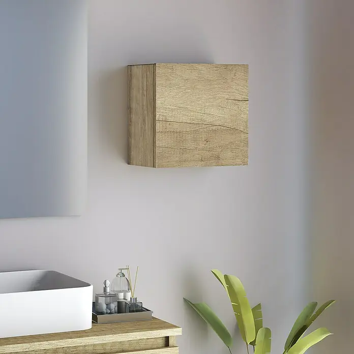 Artysan Armario colgante de baño Cubo - L x An x Al: 16,6 x 30 x 30 cm, Nature - Un armario de madera cuadrado está montado en la pared sobre un lavabo y artículos de aseo. Una planta de interior añade un ambiente relajante.