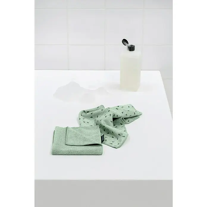 Brabantia Paños de cocina Limpiaplatos de microfibra - Material: Materiales naturales, 2 ud. - Dos paños de cocina estampados de color verde claro y una botella de jabón líquido sobre una superficie blanca.