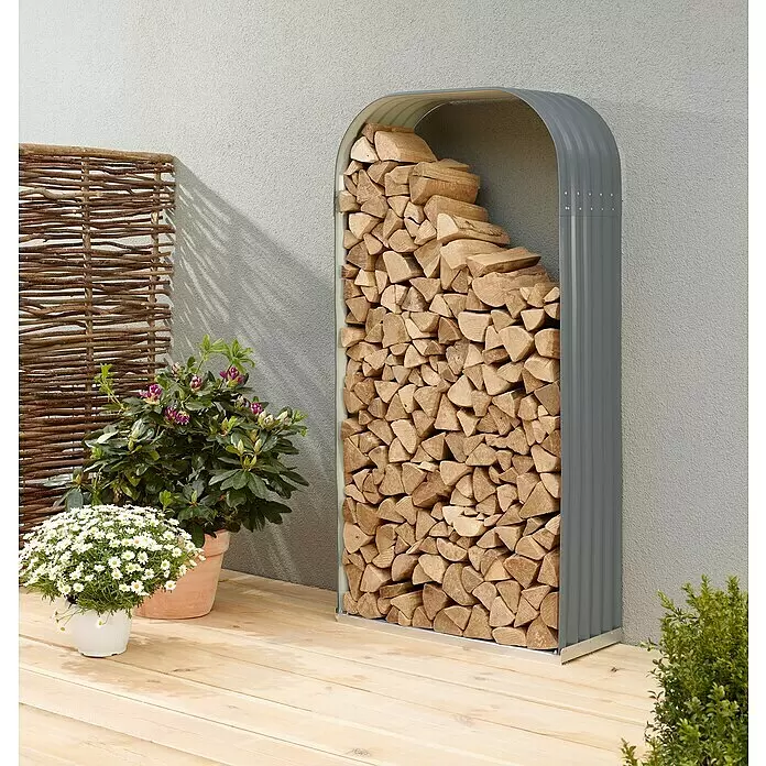 Vitavia Kaminholzregal Lignum 401 - 40 x 99 x 200 cm, Stahl, Granit - Graues, gewölbtes Brennholzregal aus Wellblech, gefüllt mit Holzscheiten, auf einer Holzterrasse.