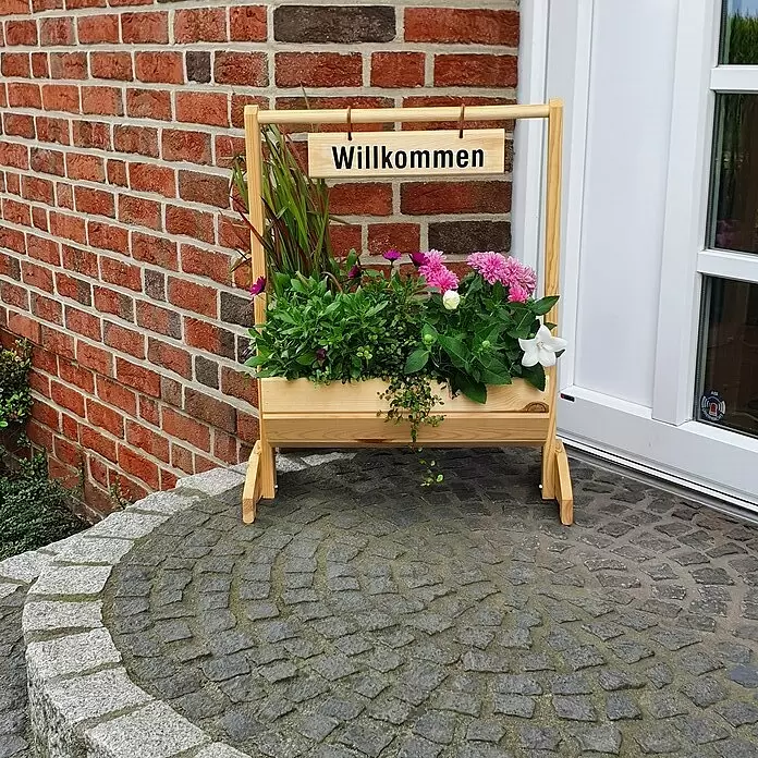 Promadino Pflanzkasten Willkommen - Außenmaß (L x B x H): 59 x 30 x 73 cm, Holz, Braun - Hölzerner Pflanzenständer mit bunten Blumen und einem 'Willkommen'-Schild, an einem Hauseingang platziert.