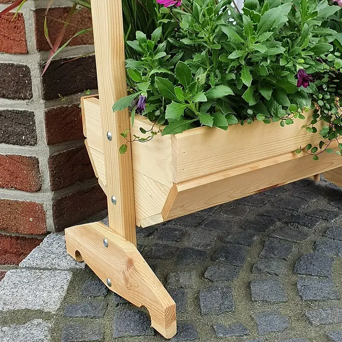 Promadino Pflanzkasten Willkommen - Außenmaß (L x B x H): 59 x 30 x 73 cm, Holz, Braun - Ein detailreicher Blick auf einen hölzernen Pflanzkasten mit üppigen Grünpflanzen, der durch seine natürliche Holzstruktur und robuste Bauweise besticht.