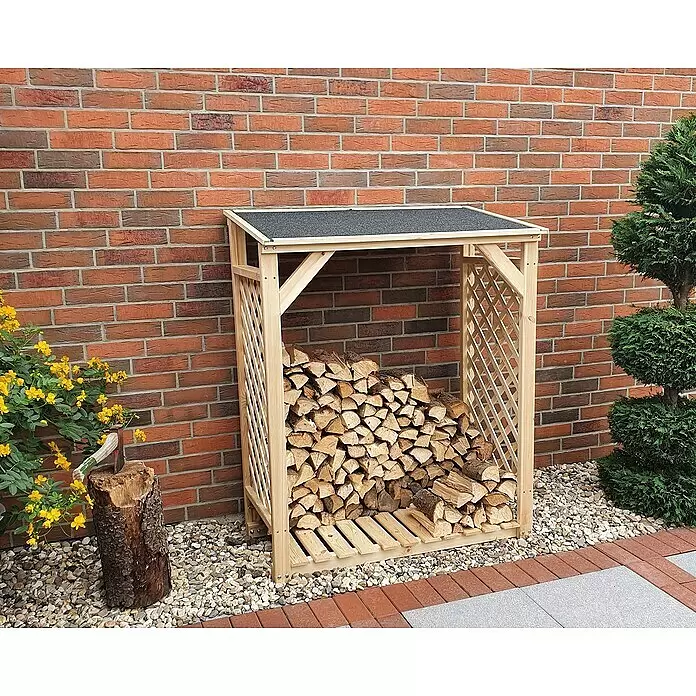 Promadino Kaminholzregal Speyer - 120 x 68 x 148 cm, Holz, Natur, Ohne Wetterschutz - Helles Holz Brennholzregal mit schwarzem Dach, gefüllt mit Holzscheiten, vor einer Ziegelwand im Freien.