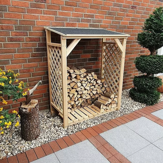 Promadino Kaminholzregal Speyer - 120 x 68 x 148 cm, Holz, Natur, Ohne Wetterschutz - Helles Holzregal für Brennholz mit schwarzem Dach, gefüllt mit Holzscheiten, steht vor einer Ziegelwand im Freien.
