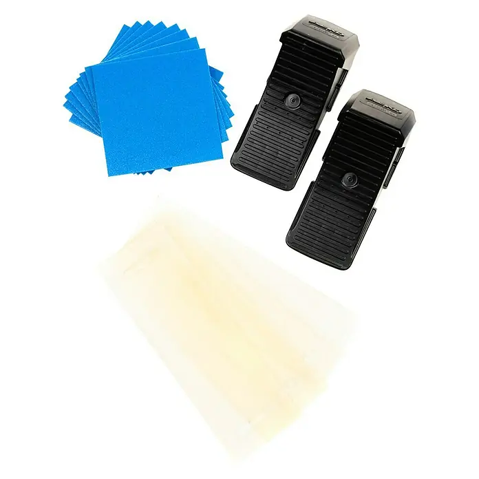 Stema Ladungssicherungs-Set bis LC 2000 daN - 23 -tlg. - Das Bild zeigt eine Nahaufnahme von zwei schwarzen Akupunkturgeräten, blauen und weißen Pads auf einem schwarzen Hintergrund.