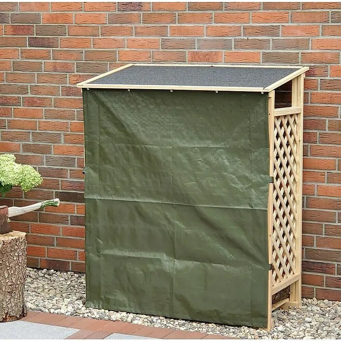 Promadino Kaminholzregal Speyer - 120 x 68 x 148 cm, Holz, Natur, Mit Wetterschutz - Ein Holzlager mit grüner Plane vor einer Backsteinmauer, ideal zum Schutz von Brennholz vor Witterungseinflüssen und zur stilvollen Lagerung im Garten.