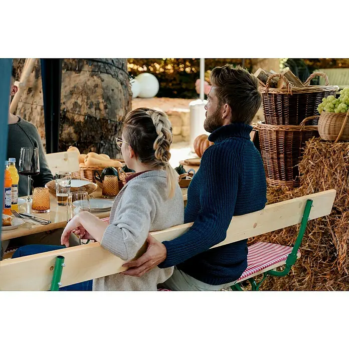 Sunfun Bierzeltgarnitur - Tisch (L x B x H): 220 x 50 x 77 cm, Bank (B x T x H): 220 x 25 x 49 cm, Mit Rückenlehne, Nadelholz/Stahl, Lasiert, Naturbraun/Grün - Bild von Menschen, die an einem Tisch sitzen, an dem Getränke und Speisen stehen, wobei der Fokus auf der geselligen Atmosphäre und den angebotenen Produkten liegt.
