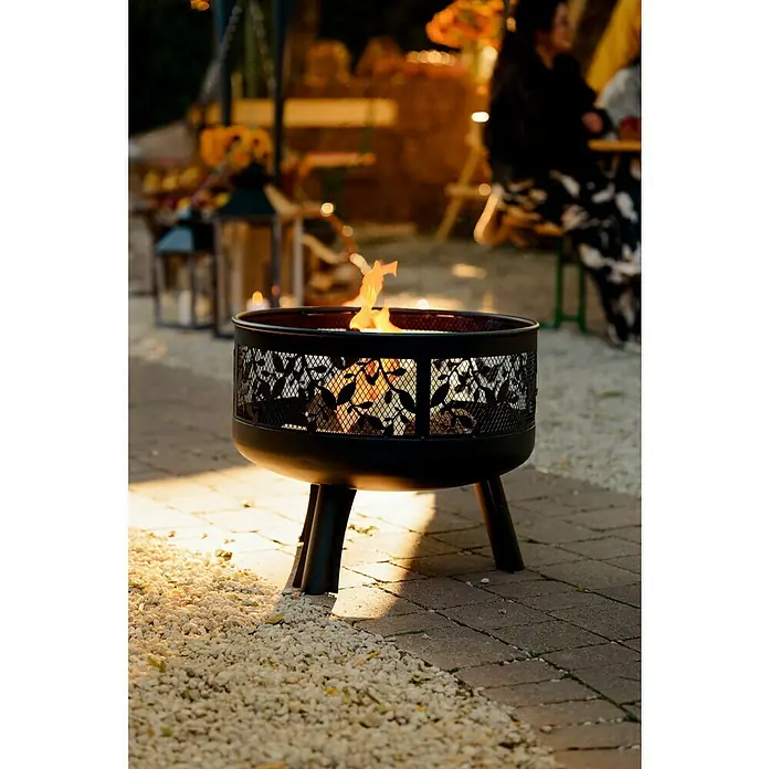 Buschbeck Feuerschale LeavesDurchmesser: 63 cm, Stahl - Ein schicker, schwarzer Feuerkorb mit Blattmuster steht auf einer Terrasse und sorgt für Wärme und Ambiente im Freien.