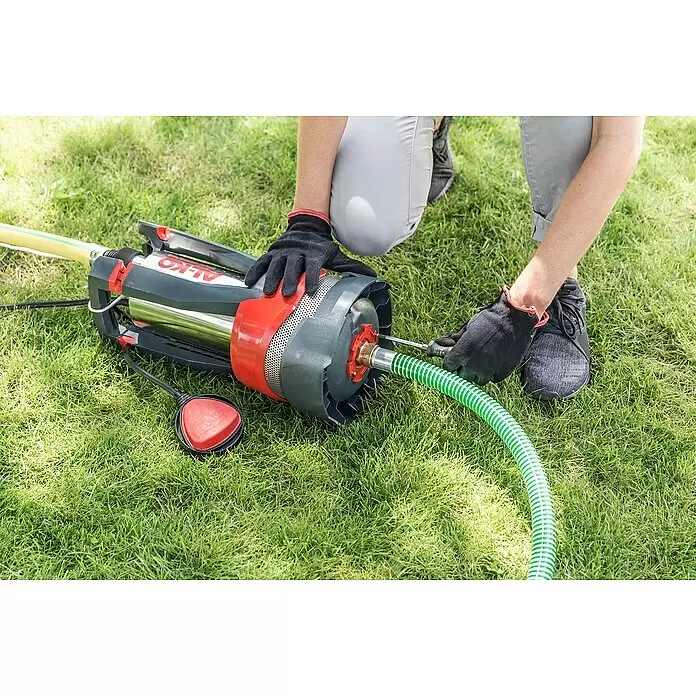 AL-KO Premium Drucktauchpumpe Dive 5600/44 Automatic - 1.200 W, Max. Fördermenge: 5.600 l/h - Person schließt grünen Schlauch an graue und rote AL-KO Tauchpumpe an.