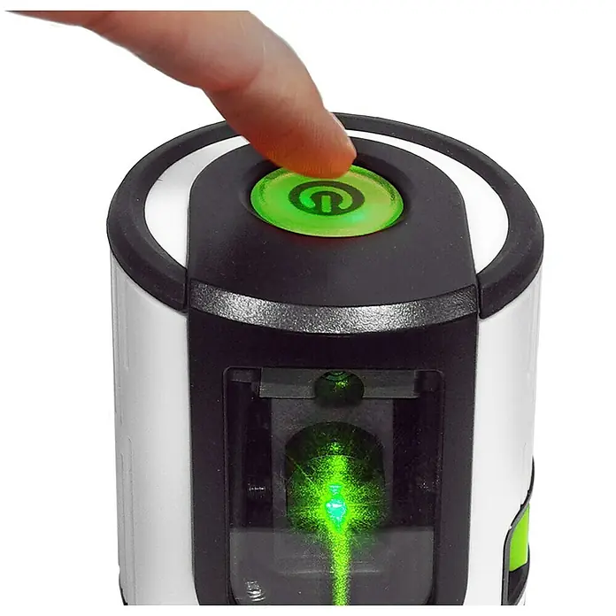 Laserliner Kreuzlinienlaser EasyCross Work - Messbereich: 0,05 - 40 m - Detailaufnahme eines Laser-Nivelliergeräts mit Finger auf dem grünen Einschaltknopf, der einen grünen Laserstrahl projiziert.