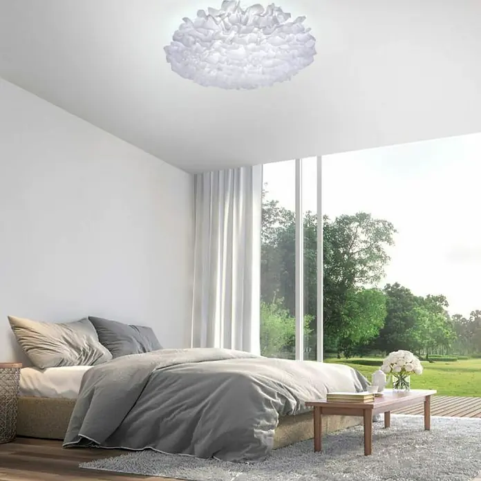 Just Light Plafón LED redondo Xenia - Ø x Al: 75 x 20 cm, Blanco - Una lámpara de techo blanca y esponjosa adorna un dormitorio luminoso, realzado por una gran ventana con vistas a un exuberante paisaje verde.