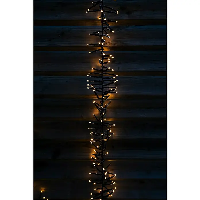 Tween Light Cadena de luces LED - Para exterior, Largo: 8,15 m, 768 ud., Funcionamiento en red, Color de luz: Blanco cálido - Guirnalda de luces festiva con LEDs blancos cálidos sujeta a una superficie de madera oscura, creando un ambiente acogedor.
