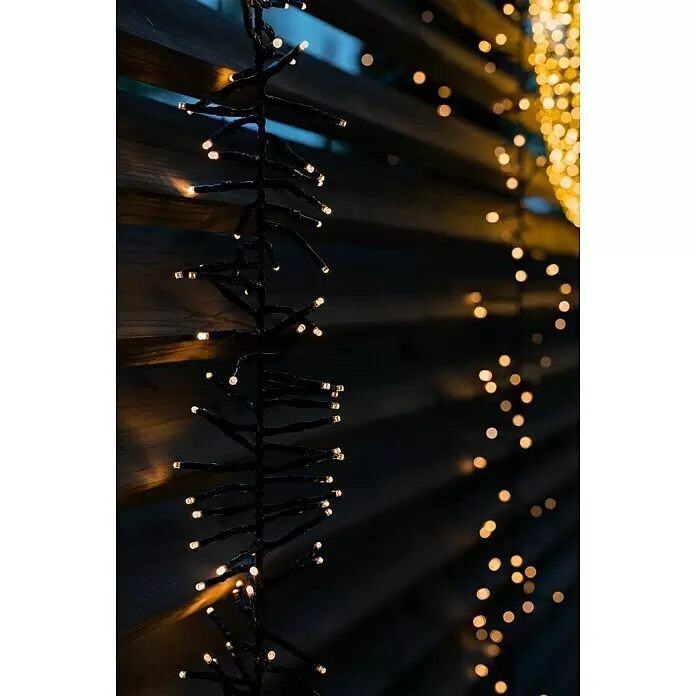 Tween Light LED-Clusterlichterkette - Außen, Länge: 8,15 m, 768 Stk., Netzbetrieben, Lichtfarbe: Warmweiß - Warmweiße LED-Lichterkette mit dunklen Kabeln, die stimmungsvolles Licht vor einem unscharfen Hintergrund spendet.