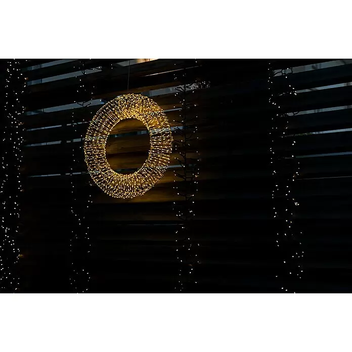Tween Light LED-Clusterlichterkette - Außen, Länge: 8,15 m, 768 Stk., Netzbetrieben, Lichtfarbe: Warmweiß - Großer goldener LED-Lichterkranz hängt an dunkler Holzlattenwand, flankiert von vertikalen LED-Lichterketten.
