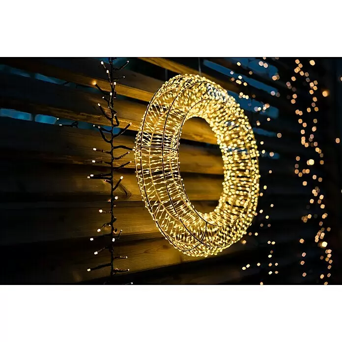 Tween Light LED-Clusterlichterkette - Außen, Länge: 8,15 m, 768 Stk., Netzbetrieben, Lichtfarbe: Warmweiß - Gold-gelber LED-Lichterkranz mit Drahtrahmen, hell leuchtend vor dunklem Holzhintergrund mit weiteren Lichterketten.