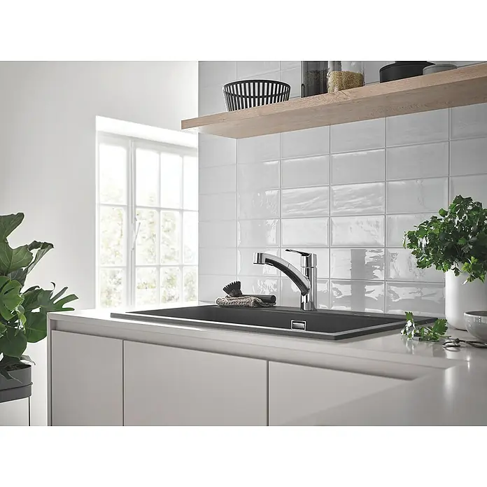 Grohe QuickFix Spültischarmatur Start - Chrom, Ausziehbar, Glänzend - Stilvolle Küchenspüle mit Armatur in einer hellen, modernen Küche. Die Spüle ist aus dunklem Material und die Armatur ist verchromt.