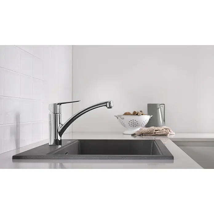 Grohe QuickFix Spültischarmatur Start - Ausladung Armatur: 227 mm, Chrom, Schwenkbereich: 140 ° - Nahaufnahme eines modernen Chrom-Wasserhahns an einer grauen Spüle in einer hellen Küche, der ein elegantes Design und hohe Funktionalität vereint.