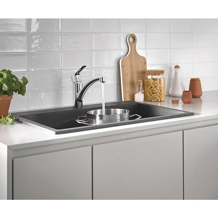 Grohe QuickFix Spültischarmatur Start - Ausladung Armatur: 227 mm, Chrom, Schwenkbereich: 140 ° - Elegante Küchenspüle mit Armatur und dekorativen Elementen. Das Becken ist aus dunklem Material gefertigt und fügt sich nahtlos in die helle Arbeitsplatte ein.