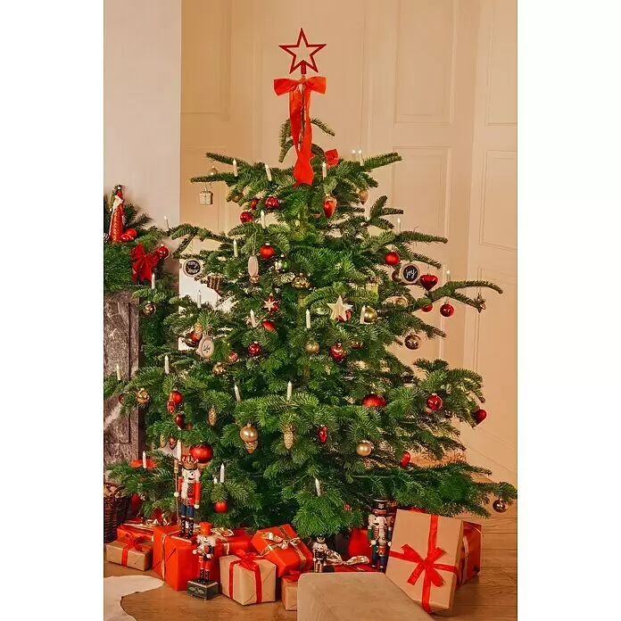 Christbaumkugel-Set - Rot, Kunststoff, 75 Stk. - Ein geschmückter Weihnachtsbaum mit roten und goldenen Kugeln, weißen Kerzen und einem roten Stern, umgeben von verpackten Geschenken.