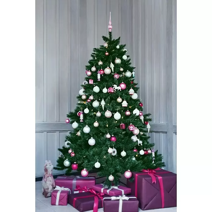 Dekofigur Weihnachtslama - L x B x H: 23 x 13 x 42 cm, Textil, Weihnachtswichtel, Schneemann - Ein geschmückter Weihnachtsbaum mit rosa, weißen und goldenen Kugeln, Neuheiten und magentafarbenen Geschenken darunter, vor einer getäfelten Wand.