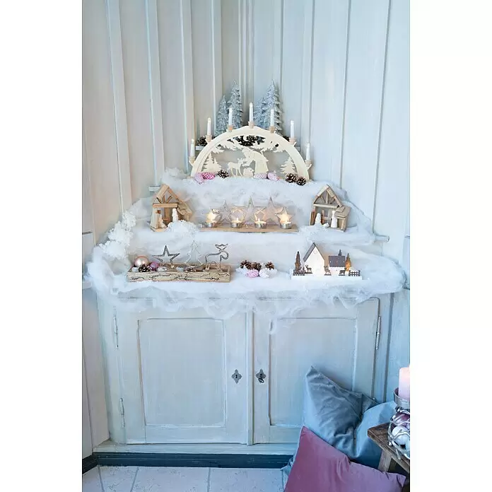 Dekofigur Stern, Tanne und Elch auf Holzsockel - L x B x H: 3,5 x 10 x 13 cm, Holz, Hirsch - Festliche Weihnachtsdekoration auf einem Schrank, mit einem Holzbogen mit Kerzen, Kunstschnee, kleinen Häusern und glitzernden Sternen in einer gemütlichen Winterszene.