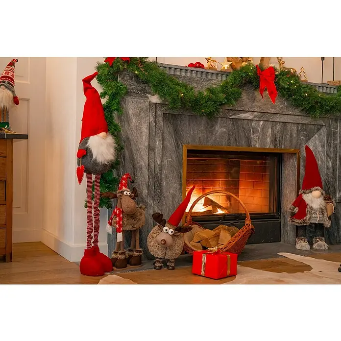 Dekofigur mit Wackeleffekt - L x B x H: 26 x 25 x 53 cm, Textil - Weihnachtliche Szene mit dekorativem Kamin, Wichteln, Elchen und einem Geschenk, die festliche Stimmung verbreiten.
