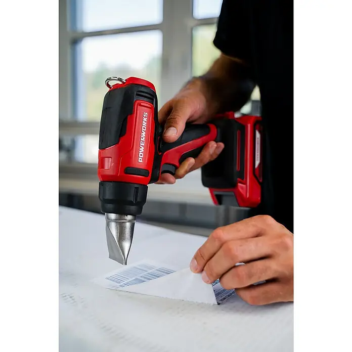 Powerworks Akku-Heißluftgebläse P24HG - 24 V, Ohne Akku, Temperaturbereich: 550 °C - Nahaufnahme einer Powerworks Heißluftpistole in Aktion, ideal zum Ablösen von Aufklebern.