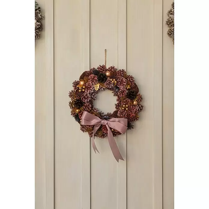 Dekokranz mit Tannenzapfen - Durchmesser: 40 cm, Beere, Gold - Rustikaler Weihnachtskranz aus mattierten Tannenzapfen, goldenen Kugeln und rosa Schleife an einer hellen Holztür.