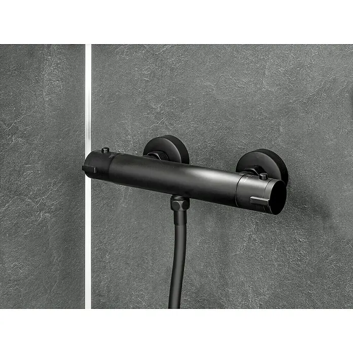 Camargue Zapo Brausethermostat - Schwarz, Matt - Nahaufnahme eines modernen, mattschwarzen Thermostat-Duschmischers mit Schlauchanschluss vor einer grauen Wand.