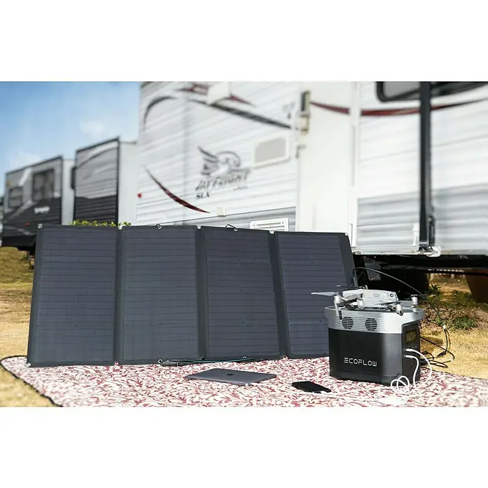 EcoFlow Solarmodul faltbar - L x B x H: 157 x 68 x 2,4 cm, 160 W - Eine EcoFlow Powerstation mit Solarmodul und einer Drohne auf einer Decke, ideal für Campingausflüge.