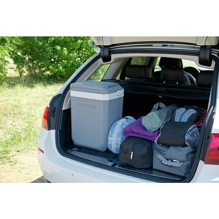 Campingaz Kühlbox Powerbox Plus - 28 l, 31 x 41 x 47 cm - Im Kofferraum eines Autos befindet sich eine Campingaz Kühlbox neben mehreren Taschen.