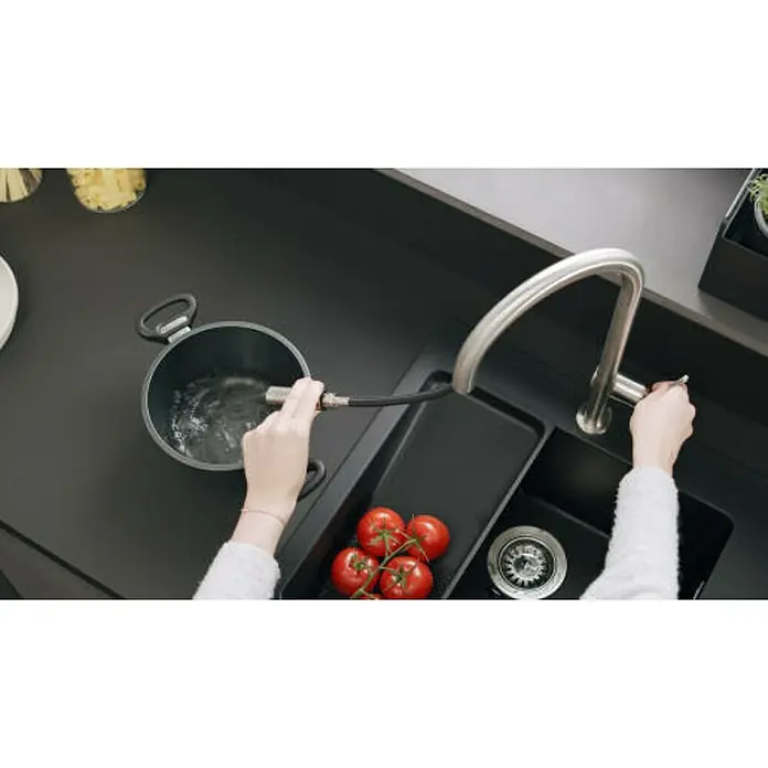 Hansgrohe Spültischarmatur Talis M54 210 - Anzahl Strahlarten: 2 Stk., Schwarz, Matt - Nahaufnahme einer modernen Küchenspüle mit Armatur, einem Topf und frischen Tomaten, ideal für Kochbegeisterte.