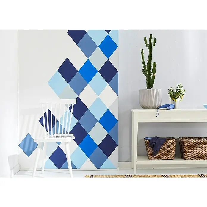 Frogtape Cinta de pintor - 41 m x 3,6 cm - Idea de diseño interior con una consola blanca, cactus, cestas y una pared con un patrón de diamantes azules para un ambiente moderno.